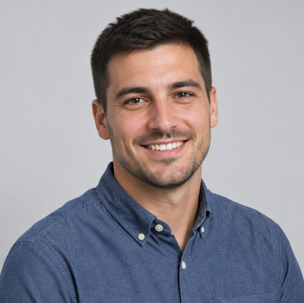 Studio portrait of a smiling man with short dark hair