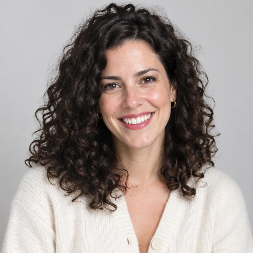 Studio portrait of a smiling woman with curly hair